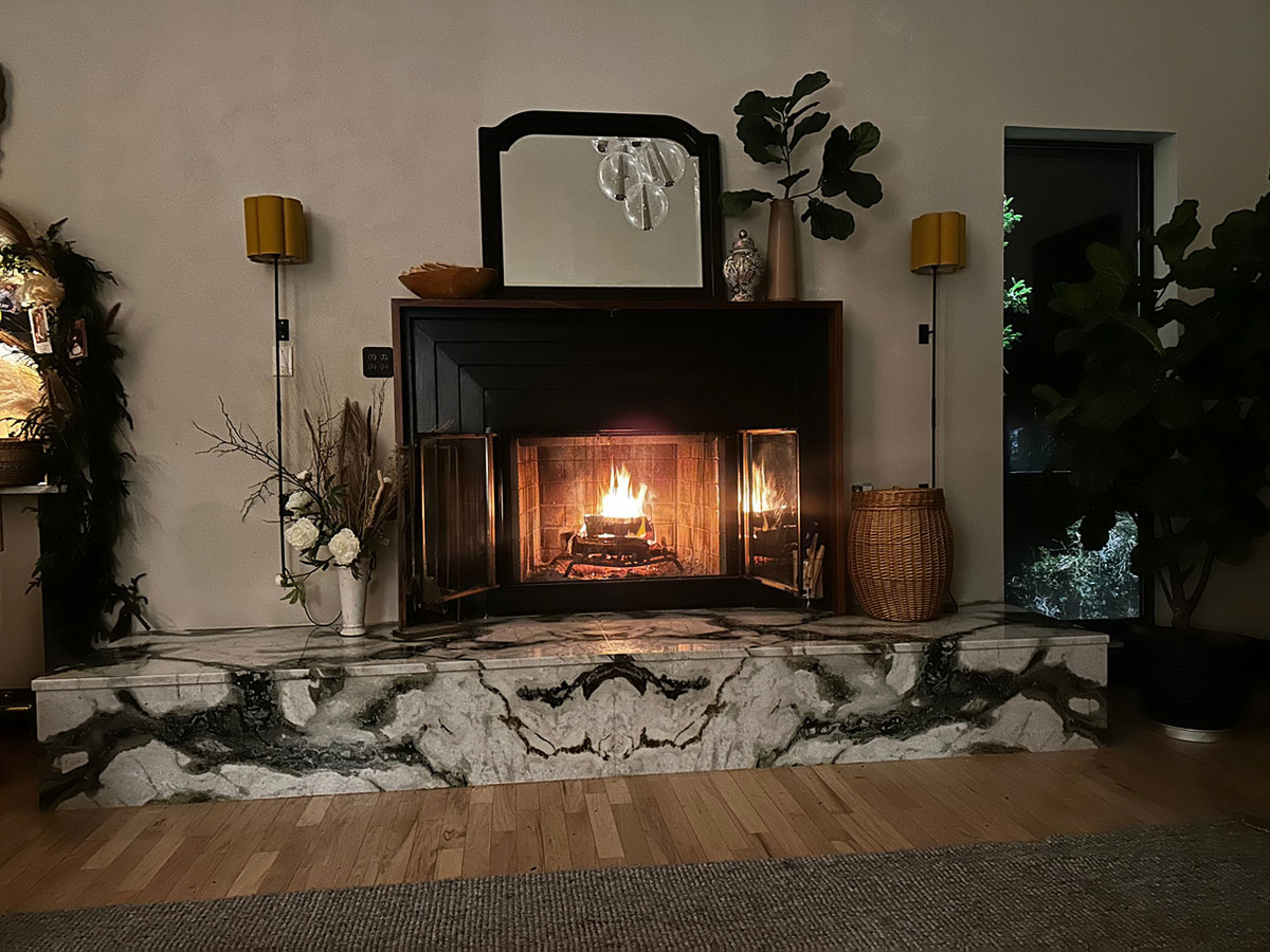 Lit fireplace with ipe wood mantle and marble platform