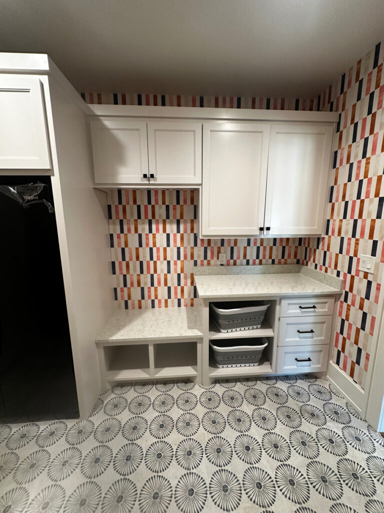 Small room with cabinets and work surfaces with geometric multicolored wallpaper
