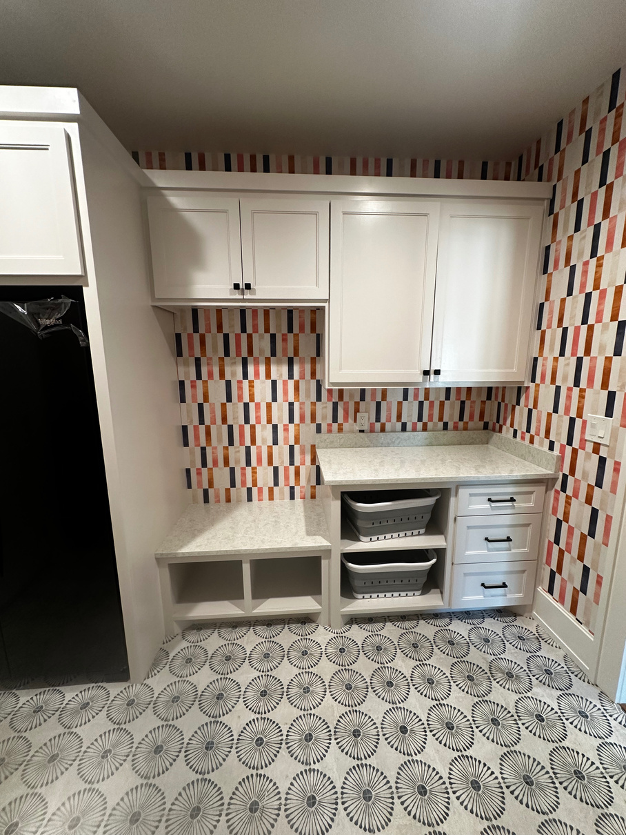 Small room with cabinets and work surfaces with geometric multicolored wallpaper